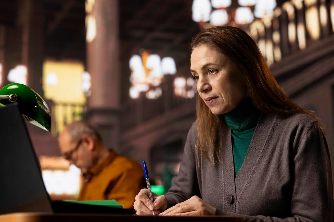 Пожилая женщина-учёный подготавливает документы для своей университетской учебной работы.